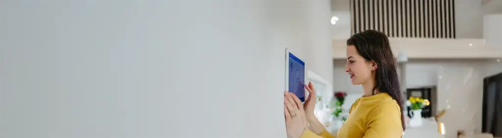 Frau bedient Heizung über Smarthome-Steuerung